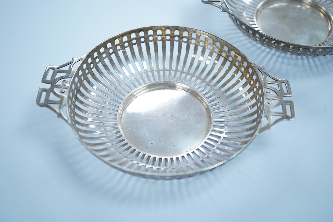 A pair of George V pierced silver two handled bonbon dishes, by Mappin & Webb, Birmingham, 1910, diameter 16.6cm over handles, possibly lacking glass inserts, 6.1oz.